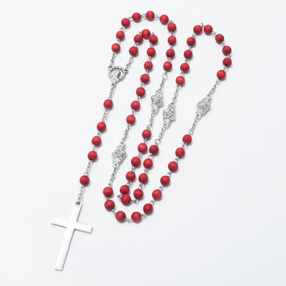 A rosary necklace featuring matte red beads and silver-tone metal links, chain, centerpiece medallions, and a white cross pendant, displayed on a clean white background.