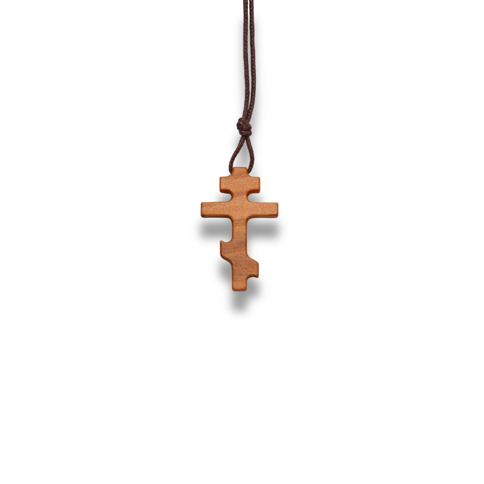 Russian orthodox olive wood cross pendant on a white background