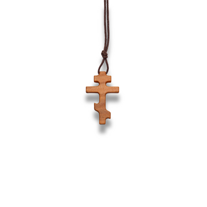 Russian orthodox olive wood cross pendant on a white background