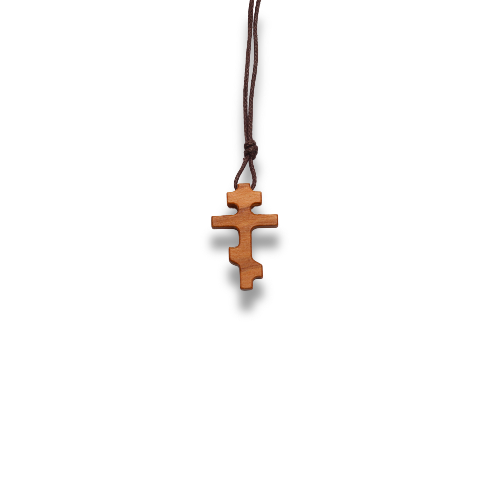 Russian orthodox olive wood cross pendant on a white background