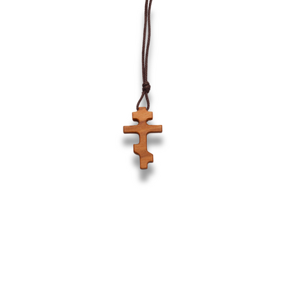 Russian orthodox olive wood cross pendant on a white background