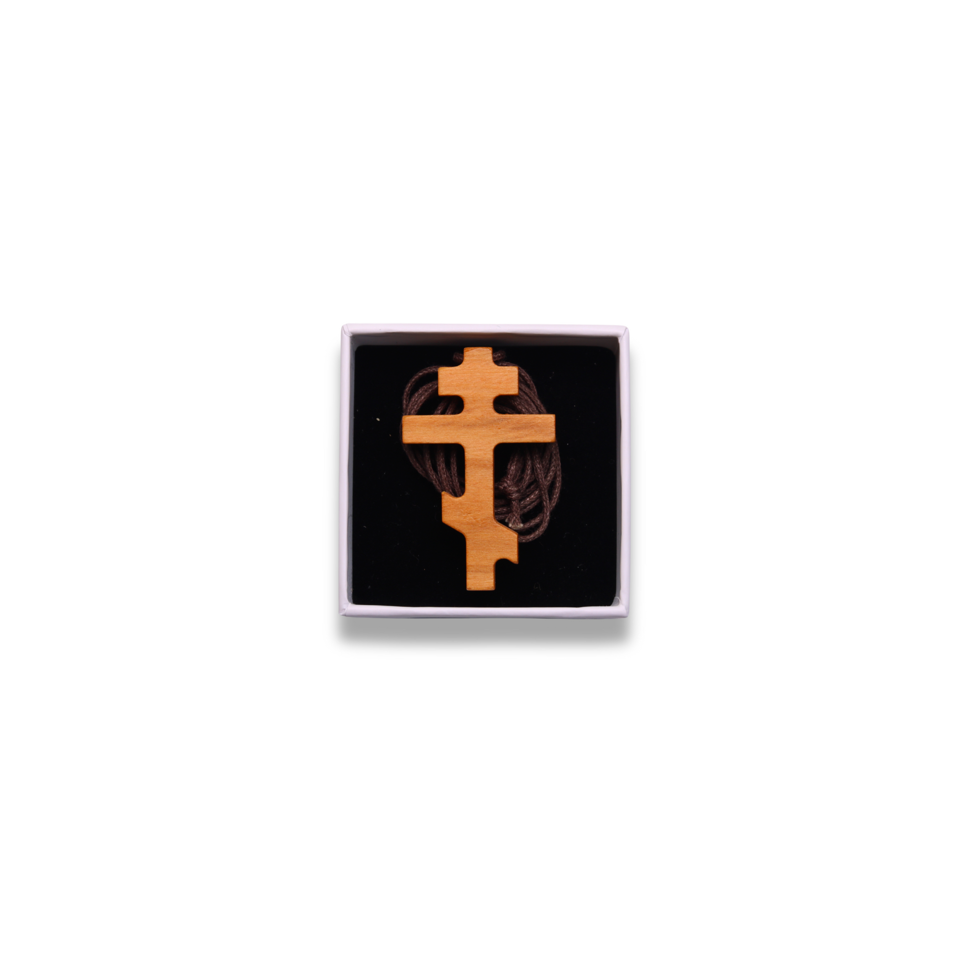 Russian orthodox olive wood cross pendant in a box on a white background