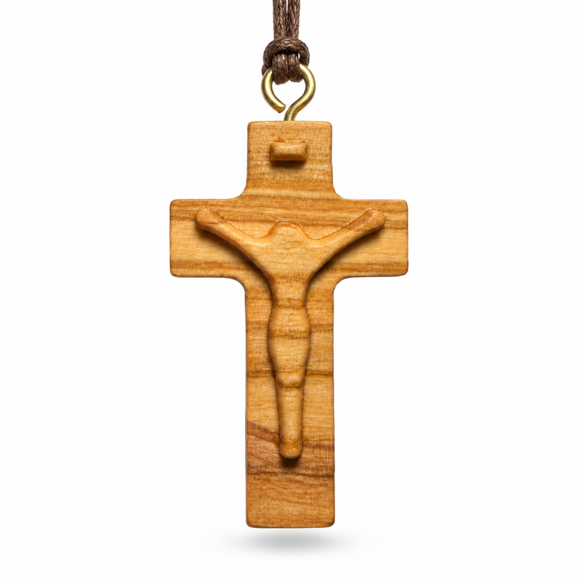 A wooden crucifix pendant with a carved figure of Jesus on a cross, suspended from a brown cord with a gold-colored metal loop, shown against a plain white background.