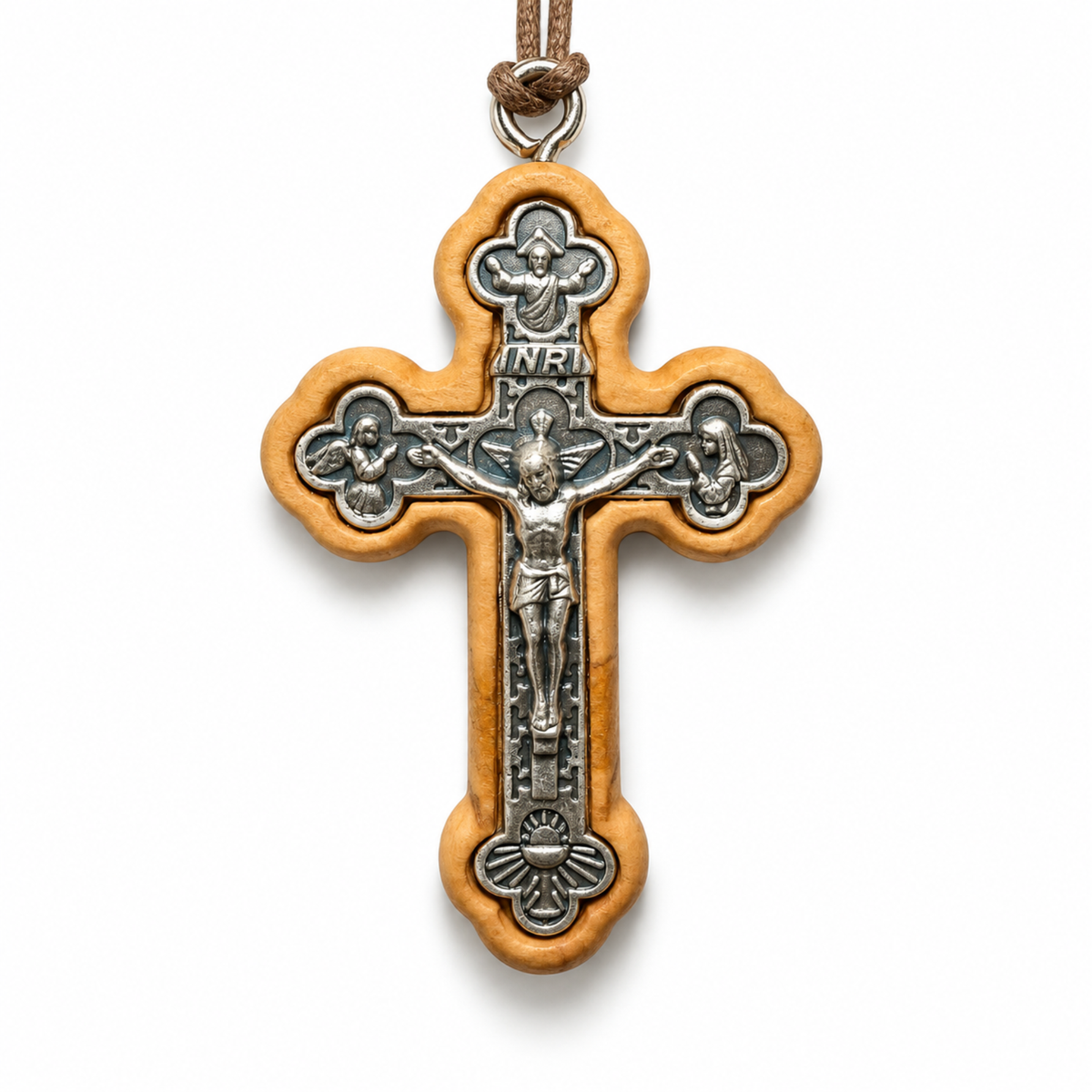 A wooden and metal crucifix pendant necklace on a white background. The cross features a light brown olive wood frame with a silver-toned metal center depicting Jesus Christ on the cross, with an INRI plaque at the top and a brown cord loop at the very top.