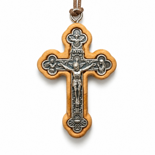A wooden and metal crucifix pendant necklace on a white background. The cross features a light brown olive wood frame with a silver-toned metal center depicting Jesus Christ on the cross, with an INRI plaque at the top and a brown cord loop at the very top.
