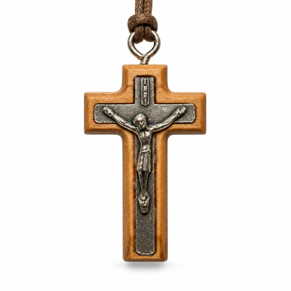 A wooden crucifix pendant with a silver-toned metal corpus and a brown cord loop at the top, shown against a plain white background.