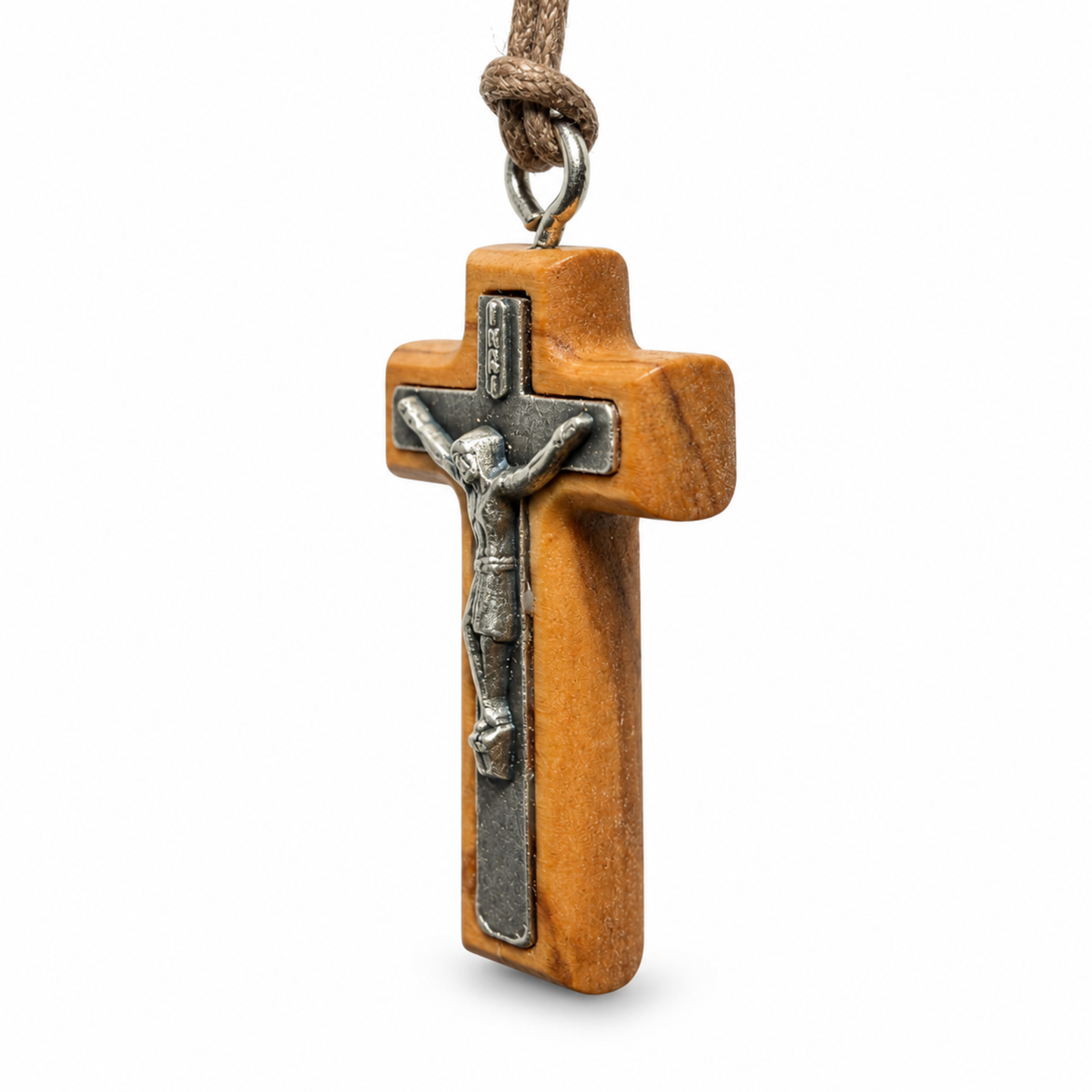 A wooden crucifix pendant with a silver-toned metal corpus of Jesus Christ, hanging from a brown cord on a white background.