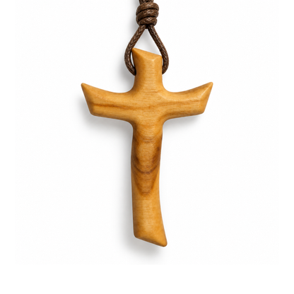 A light brown wooden cross pendant with a natural wood grain finish, suspended from a dark brown knotted cord, shown against a plain white background.