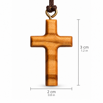 A wooden cross pendant with a brown cord and metal loop, shown on a white background with dimension lines indicating 3 cm height and 2 cm width.