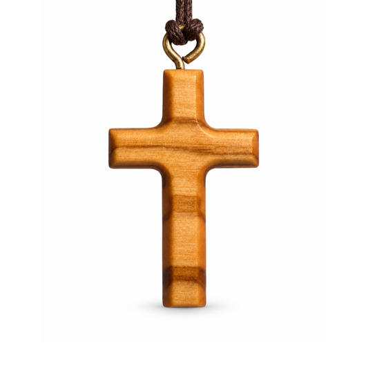 A wooden cross pendant with a natural warm brown finish, hanging from a dark brown cord with a brass-colored loop, shown against a plain white background.