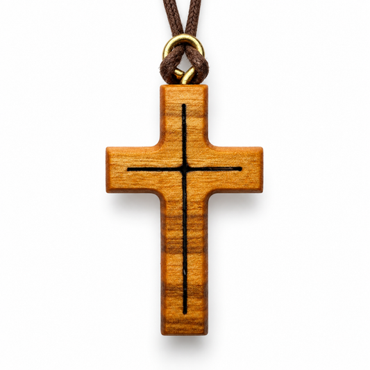 A wooden cross pendant with a black engraved cross design, hanging from a brown cord with a gold metal ring, shown on a plain white background.