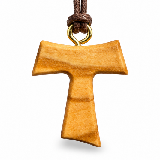 A wooden T-shaped pendant with a natural warm brown finish, suspended from a dark brown cord with a gold-colored metal loop, shown against a plain white background.