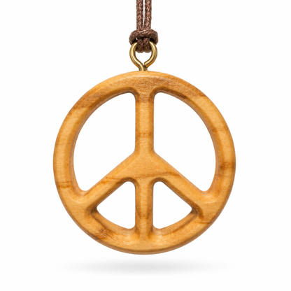 A wooden peace sign pendant necklace made from natural olive wood with a brown cord and brass ring, shown on a white background.