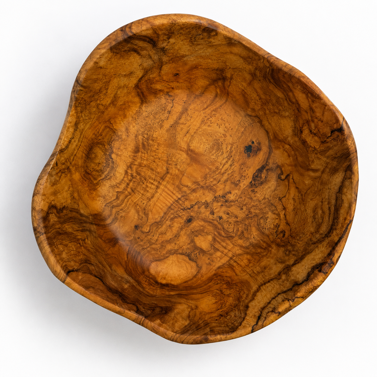 An organic-shaped wooden bowl with a rich, swirling grain pattern in warm golden-brown and amber tones, photographed from a top-down perspective on a white background.