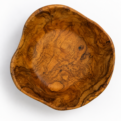 An organic-shaped wooden bowl with a rich, swirling grain pattern in warm golden-brown and amber tones, photographed from a top-down perspective on a white background.