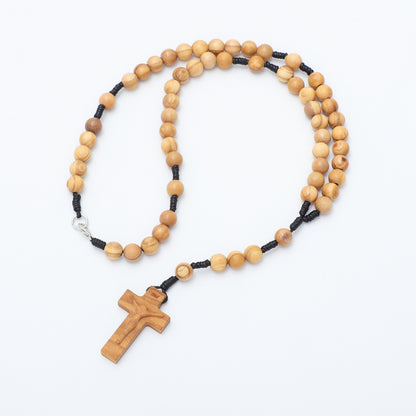 Wooden rosary with black beads on a white background