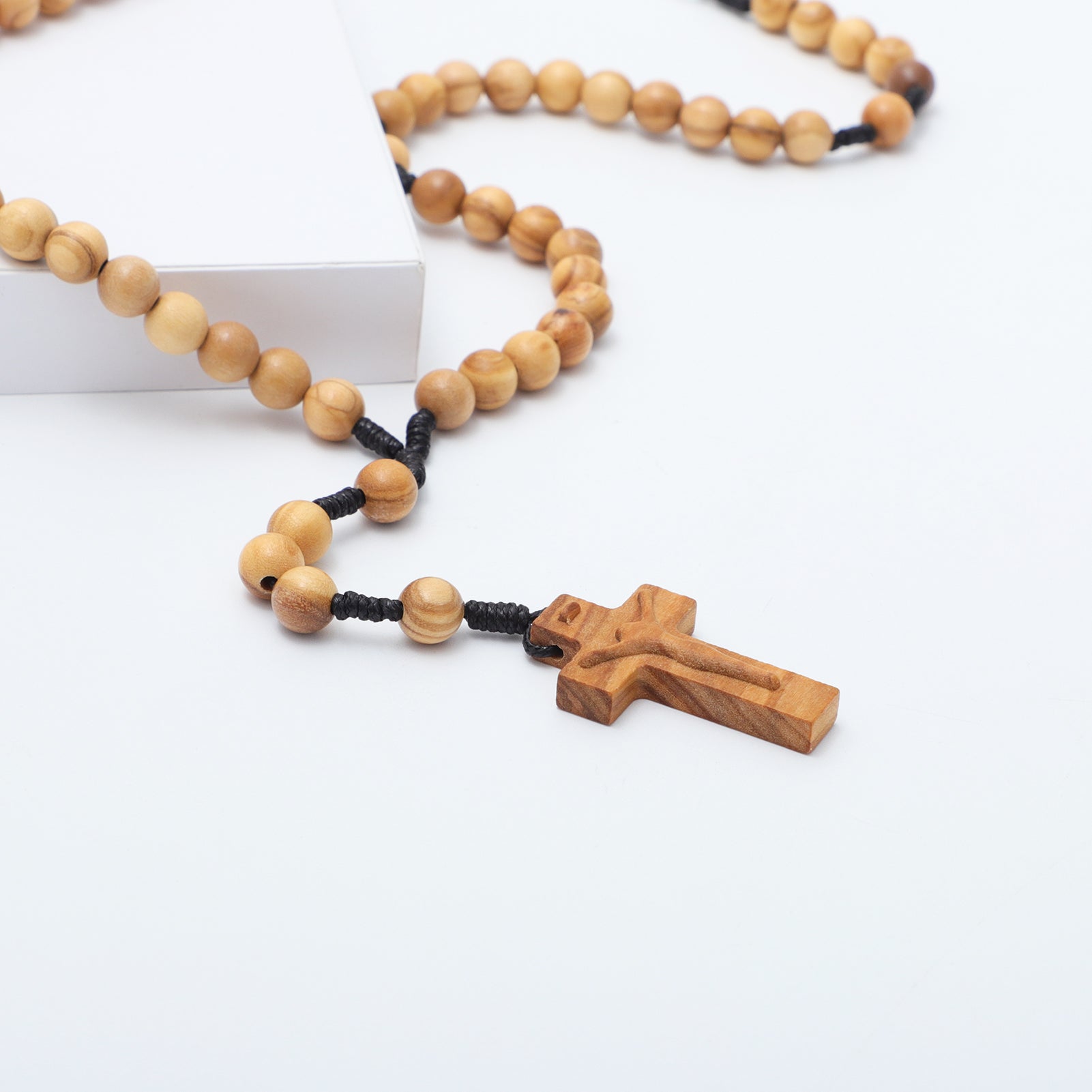 Wooden rosary with a cross pendant on a white background