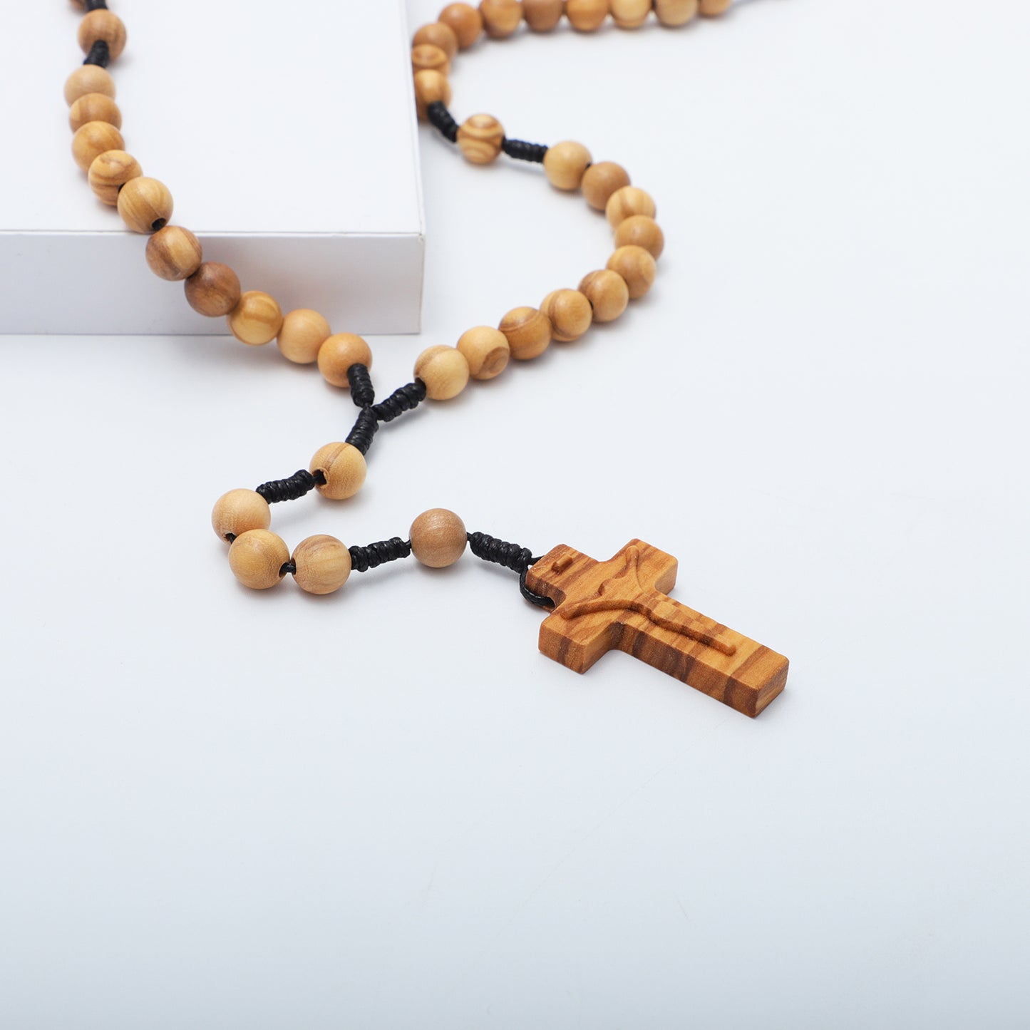 Wooden rosary with a cross pendant on a white background