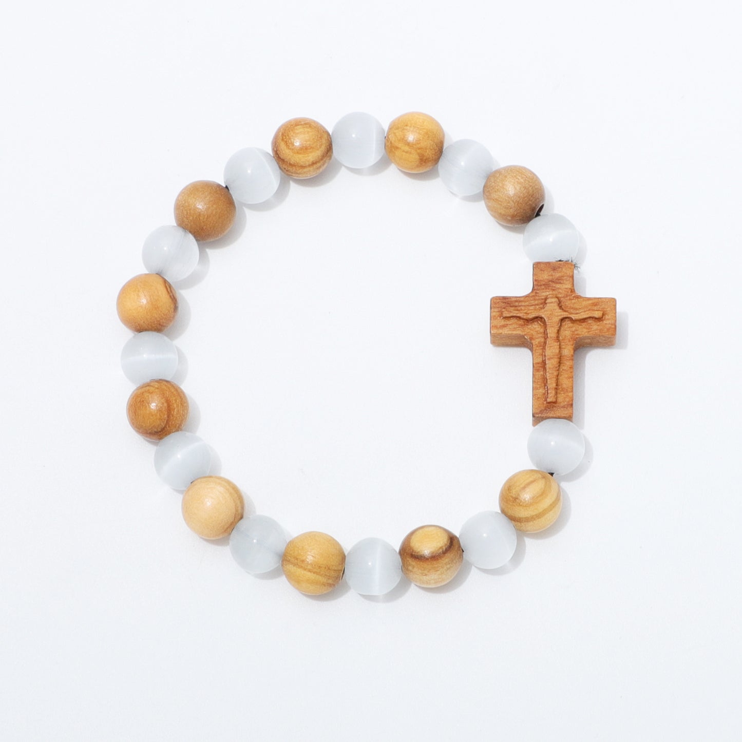 A beaded rosary-style bracelet with alternating light brown wood beads and translucent white beads, featuring a carved wooden cross on a plain white background.
