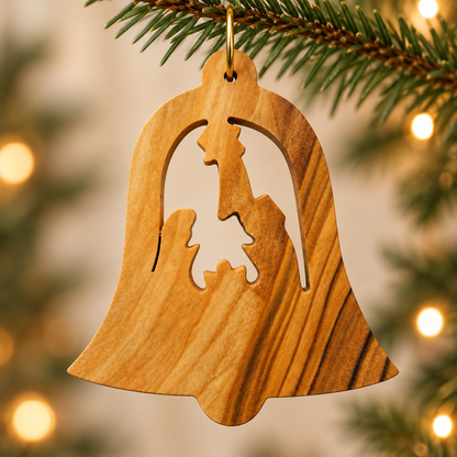 Bell-shaped olive wood ornament with Mary, Joseph and baby Jesus beneath a star, hanging among Christmas tree branches.