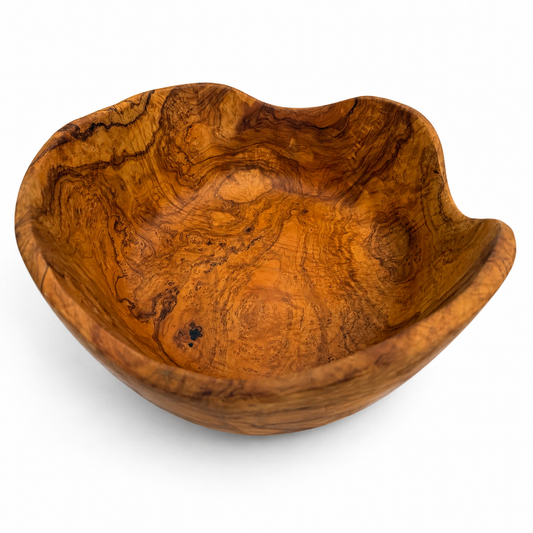 A handcrafted wooden bowl with a wavy, organic shape and rich swirling grain patterns in warm golden-brown and amber tones, photographed on a clean white background.
