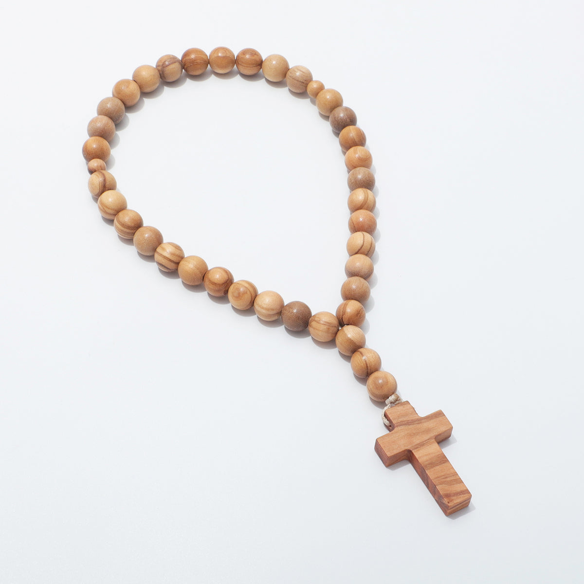 Olive wood Jesus Prayer Beads arranged in a loop with the cross at lower right