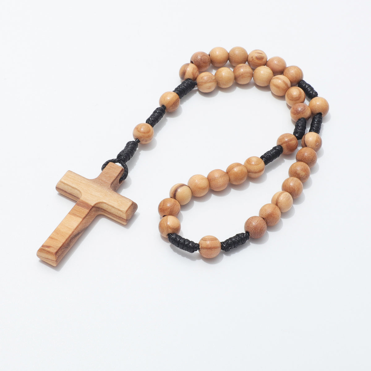 Coiled 6mm olive wood prayer beads with plain wooden cross on a white background