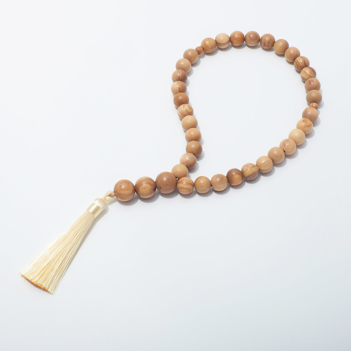 Olive wood prayer beads with 33 main beads and a cream tassel, angled full view