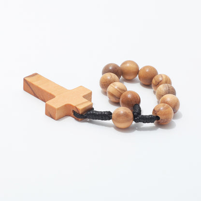 Round 10mm olive wood beads and black cord knots beside a plain cross, viewed from the side