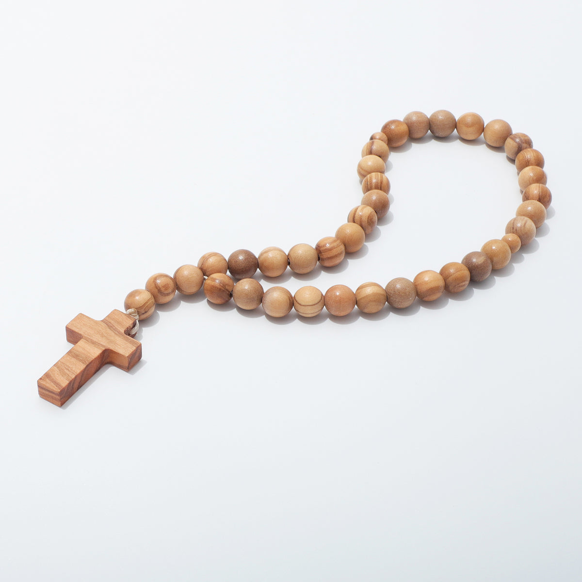 Angled view of olive wood prayer beads with smaller divider beads and a plain cross