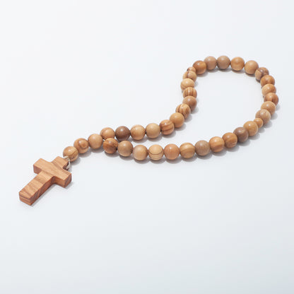 Angled view of olive wood prayer beads with smaller divider beads and a plain cross