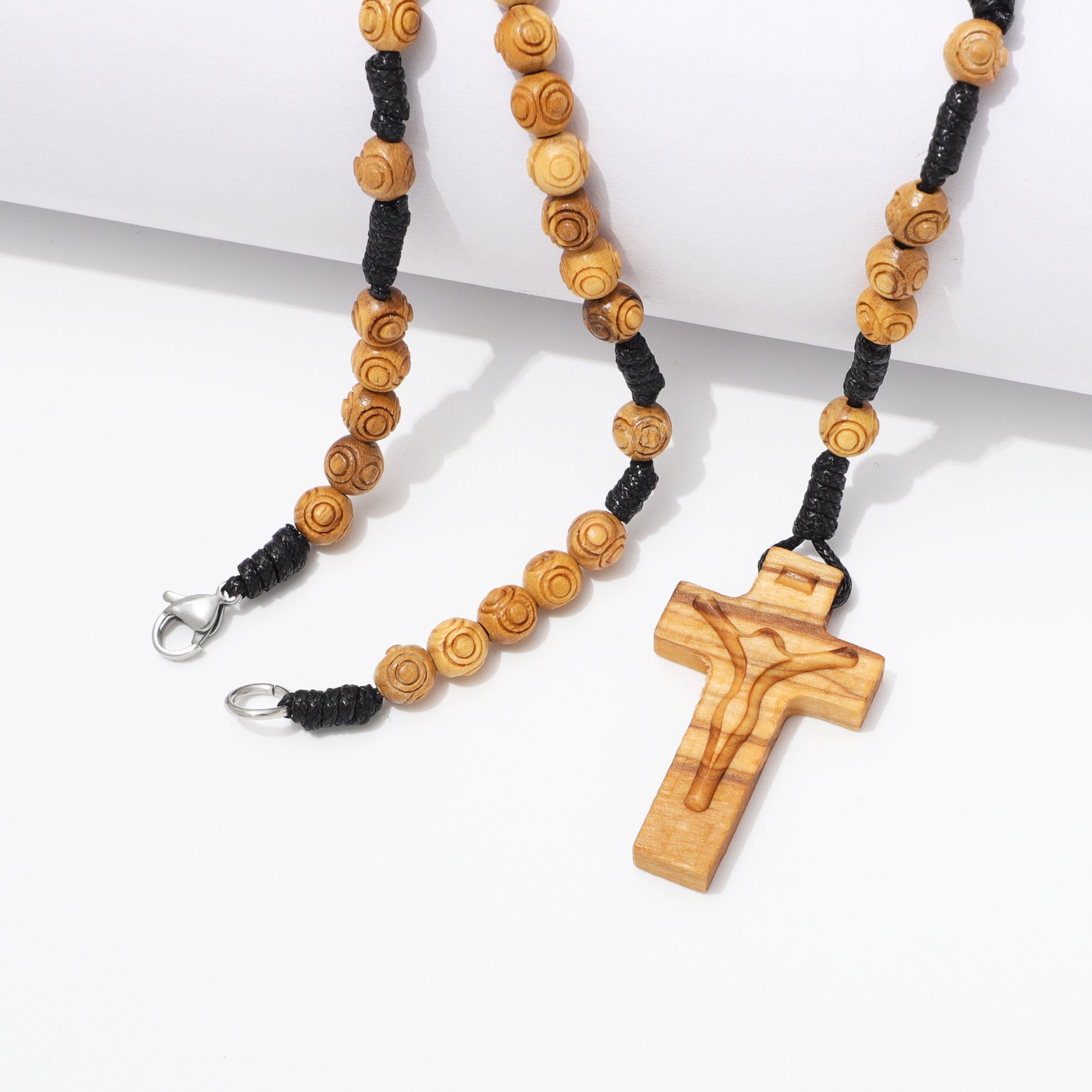 Close up of engraved 6 mm olive wood beads on handcrafted rosary necklace.