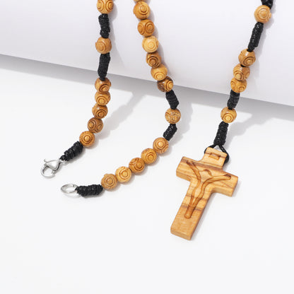 Close up of engraved 6 mm olive wood beads on handcrafted rosary necklace.