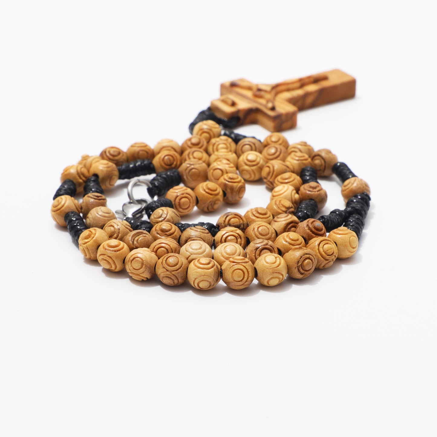 Olive wood rosary necklace showing engraved beads, hand knotted cord, and carved crucifix.
