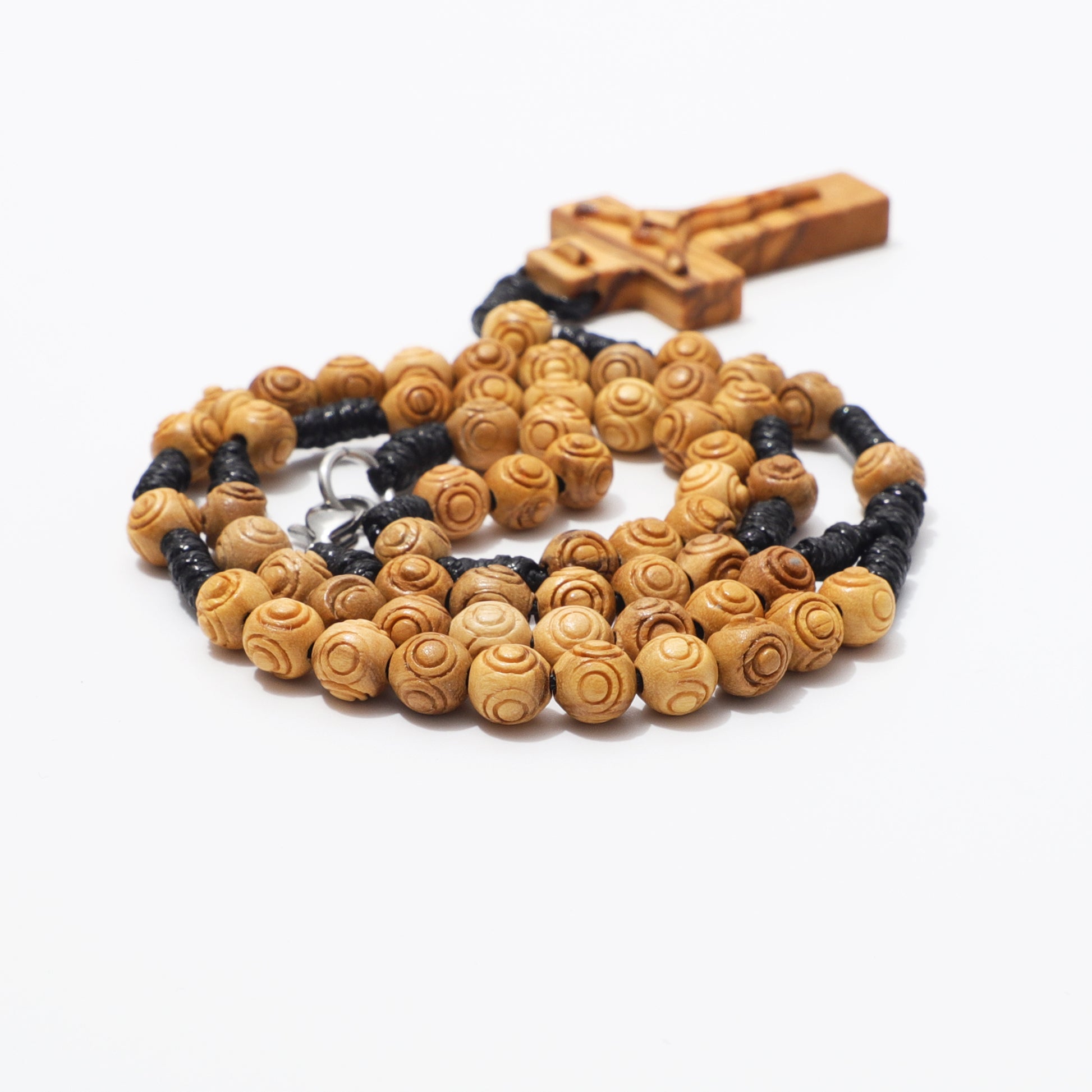 Olive wood rosary necklace showing engraved beads, hand knotted cord, and carved crucifix.