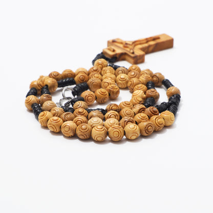 Olive wood rosary necklace showing engraved beads, hand knotted cord, and carved crucifix.