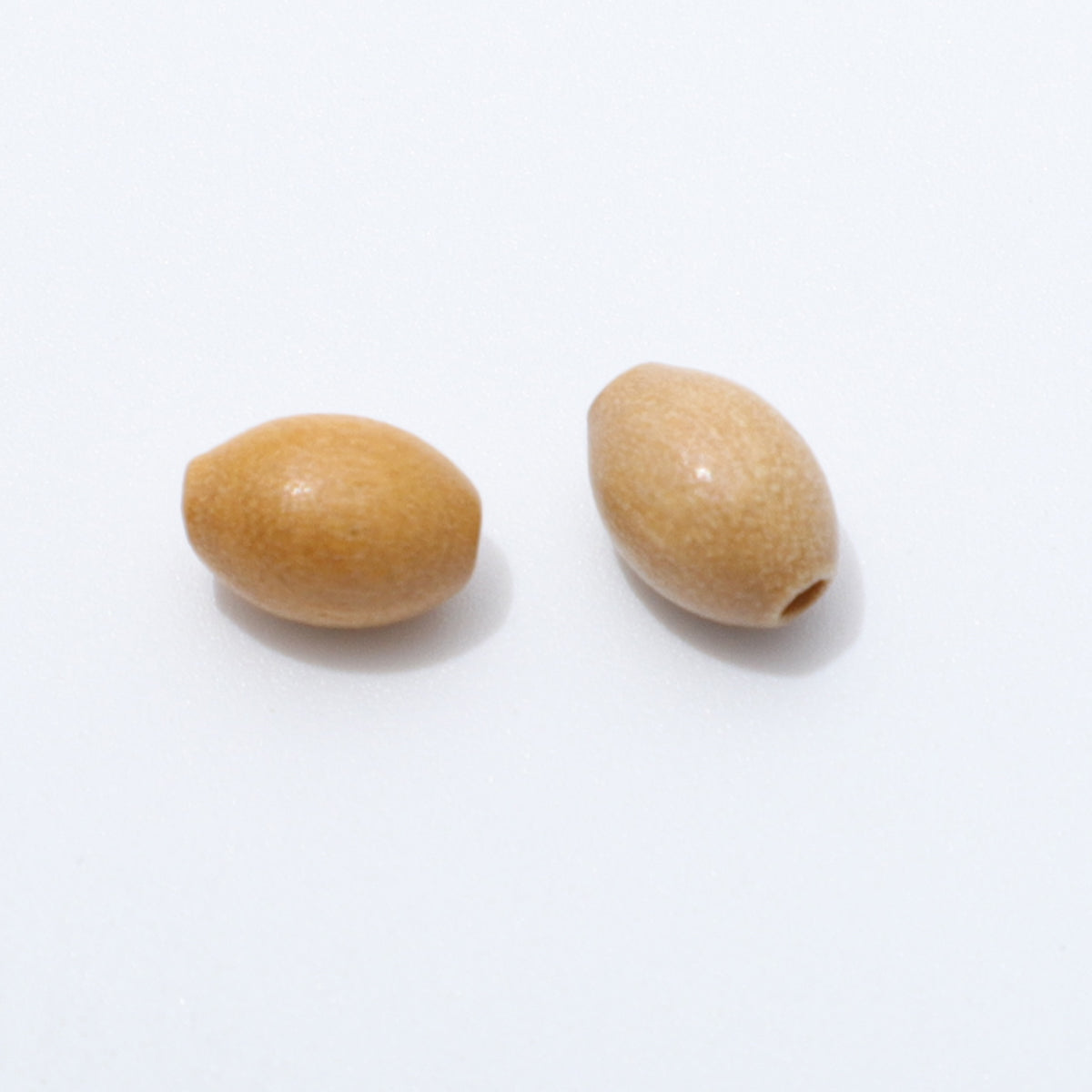 Two olive wood oval beads on a white background